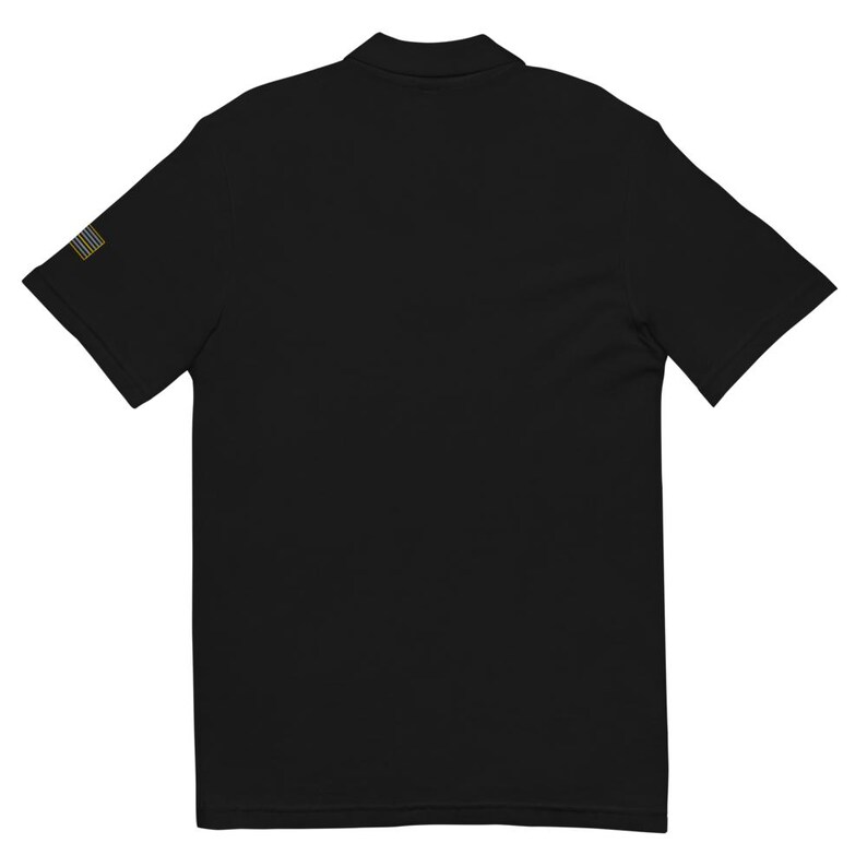 May include: A black short-sleeved polo shirt with a small American flag embroidered on the left sleeve.