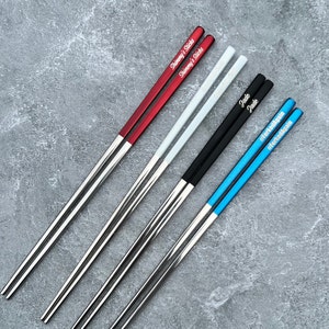 Red and silver, white and silver, black and silver, and blue and silver personalized engraved chopsticks with a personalized or blank black pull box case.