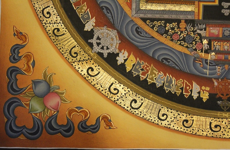 May include: A close-up of a corner of a Tibetan mandala painting. The mandala is painted on a gold background with intricate details in black, blue, and red. The mandala features a wheel of dharma, a symbol of Buddhist teachings.