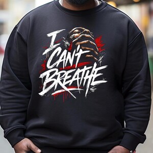 May include: Black sweatshirt with the words "I Can't Breathe" in white, with red accents and a graphic of a person's face and hands. The sweatshirt is a crew neck style.