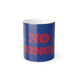 Puede incluir: Una taza de cerámica azul con las palabras "NO KINGS" en rojo, con estrellas en las letras. La taza tiene un interior blanco y un diseño sencillo y limpio.