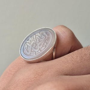 Könnte beinhalten: Ein Set aus drei Keramikbechern mit gesprenkelter, matter Oberfläche. Die Becher sind in Creme-, Hellgrau- und Dunkelgrautönen gehalten. Jeder Becher hat ein schlichtes, minimalistisches Design und einen abgerundeten Henkel.