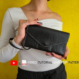 May include: Black leather clutch with white stitching and a strap. The clutch is held against a yellow background. The text "VIDEO TUTORIAL AND PDF PATTERN" is visible.