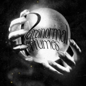 May include: A black and white image of two hands holding a crystal ball with the text "Paranormal Perfumes" written on it.