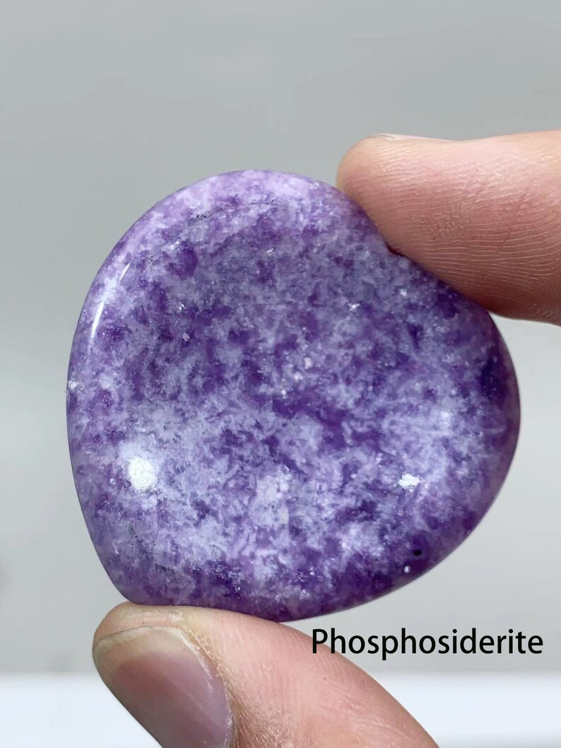 May include: A purple and white heart-shaped polished stone with the text "Phosphosiderite" below it.