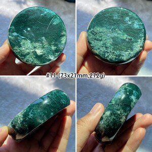 Peut inclure: Quatre images pr&eacute;sentent une pierre polie, de forme ronde et cylindrique. La pierre est d'un bleu-vert profond avec des veines blanches et bleu-vert clair. Le texte "#11-(73x21mm,212g)" est visible. Le diam&egrave;tre de la pierre est d'environ 7,3 cm.