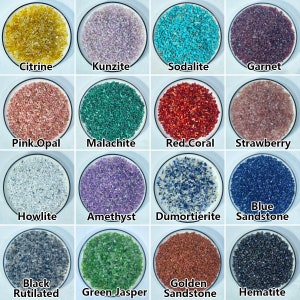 May include: A collection of 12 small bowls, each filled with a different type of gemstone chips. The gemstones include citrine, kunzite, sodalite, garnet, pink opal, malachite, red coral, strawberry quartz, howlite, amethyst, dumortierite, blue sandstone, black rutilated quartz, green jasper, golden sandstone, and hematite.
