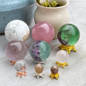 May include: A set of three ceramic mugs with a speckled, matte finish. The mugs are in shades of cream, light gray, and dark gray. Each mug has a simple, minimalist design and a rounded handle.