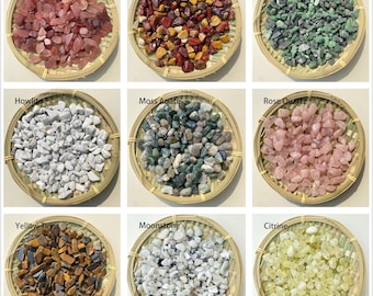 May include: Nine small bowls filled with various types of tumbled stones, including rose quartz, howlite, moss agate, moonstone, citrine, unakite, mookite, strawberry quartz, and yellow tiger's eye.