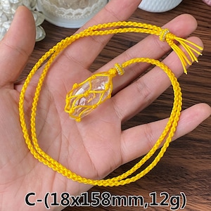 Puede incluir: Un collar de cordón amarillo con un colgante de cristal de cuarzo transparente envuelto en una red de macramé amarilla. El colgante mide 18 mm x 158 mm y pesa 12 g. C-(18x158mm,12g)