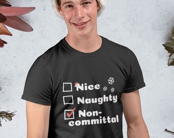 May include: A black t-shirt with a white checklist that says "Nice", "Naughty", and "Non-committal". The "Non-committal" option is checked. The person wearing the shirt is wearing a Santa hat.