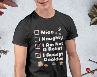 May include: A black t-shirt with a white Christmas-themed checklist that reads "Nice", "Naughty", "I Am Not A Robot", and "I Accept Cookies". The checklist has checkmarks next to "I Am Not A Robot" and "I Accept Cookies". The shirt is being worn by a person wearing a Santa hat.