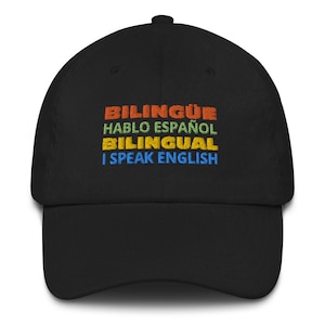 May include: Black baseball cap with the text "Bilingüe, Hablo Español, Bilingual, I Speak English" embroidered in rainbow colours.