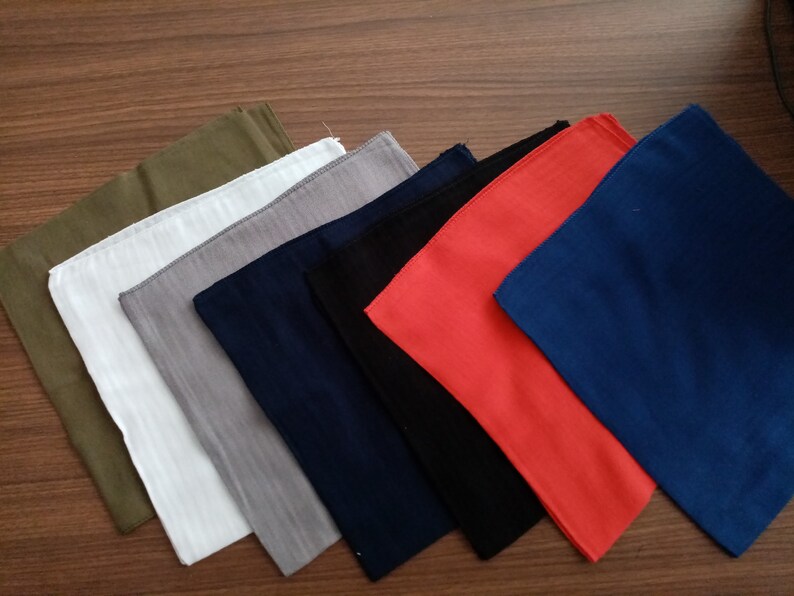 May include: A set of ten fabric squares in various colors, including green, white, gray, navy blue, black, and red. The squares are arranged in a staggered pattern, with the green square at the top and the red square at the bottom.