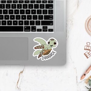 Puede incluir: Una pegatina con una tortuga de mar de dibujos animados con un caparaz&oacute;n verde y manchas marrones. La tortuga sonr&iacute;e y tiene ojos grandes. El texto "DUUUUUDE" est&aacute; escrito debajo de la tortuga.