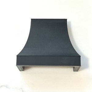Pu&ograve; includere: Cappa da cucina in metallo nero con parte superiore curva e base rettangolare.