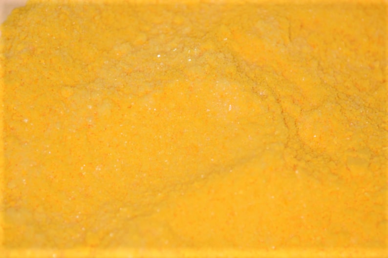 May include: A close-up of a bright yellow powder, likely turmeric or curry powder.