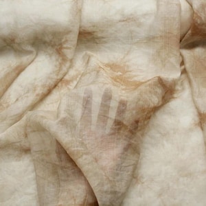 May include: A light brown fabric with a handprint pattern. The fabric is sheer and has a soft, flowing texture.