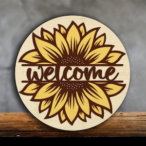 Pode incluir: Um sinal de madeira redondo com um desenho de girassol amarelo e a palavra "welcome" em texto marrom.