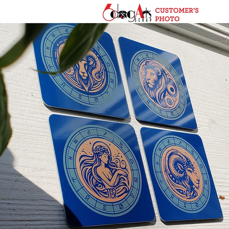 May include: Four blue square coasters with a zodiac sign design. Each coaster features a different zodiac sign with a gold and peach colored illustration. The signs are Aries, Leo, Virgo, and Capricorn.