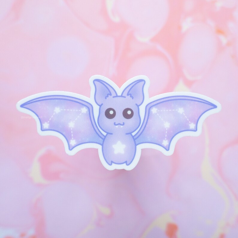 May include: A purple and blue cartoon bat with a constellation pattern on its wings. The bat has a white star on its chest and large, black eyes.