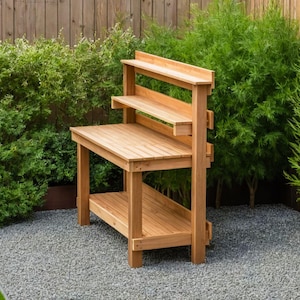Peut inclure: Un banc de travail de jardin en bois avec deux &eacute;tag&egrave;res et une large surface de travail. Le banc est en bois naturel et a un aspect rustique.