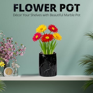 May include: A black marble flower pot with a white veined pattern, holding colorful gerbera daisies. The pot is cylindrical and sits on a white shelf. Text at the top reads "FLOWER POT" and "Décor Your Shelves with Beautiful Marble Pot."