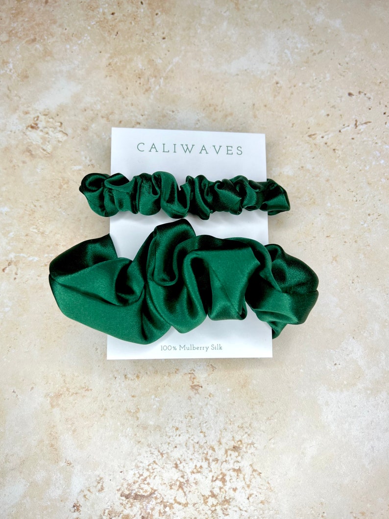 May include: Two green silk scrunchies, one larger and one smaller, on a white card with the text "CALIWAVES" and "100% Mulberry Silk".