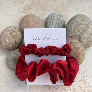 May include: Two red satin scrunchies on a white card with the text "CALIWAVES".