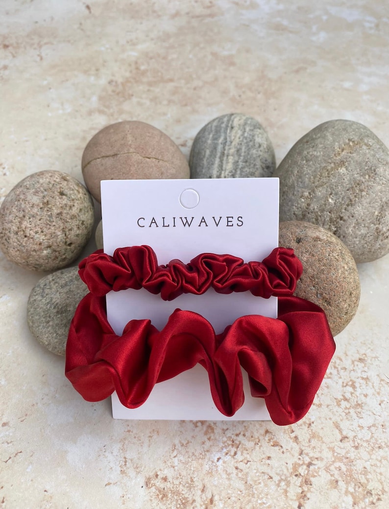 May include: Two red satin scrunchies on a white card with the text "CALIWAVES".