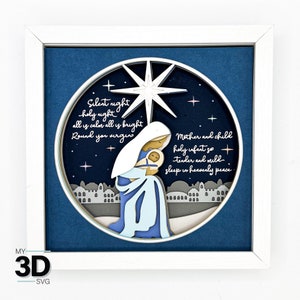 May include: A white framed 3D wood carving of the nativity scene with a blue background. The carving features Mary holding baby Jesus, a star, and the text "Silent night holy night all is calm all is bright Round you virgin Mother and child holy infant so tender and mild sleep in heavenly peace".