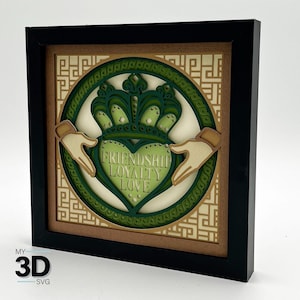 May include: A framed 3D wood carving of a Celtic knot design with a heart in the center. The heart has the words "Friendship, Loyalty, Love" inscribed on it. The carving is surrounded by a green and gold patterned frame.