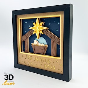 May include: A 3D layered paper craft of a nativity scene with a baby Jesus in a manger, a star above, and the text "For unto us a child is born".