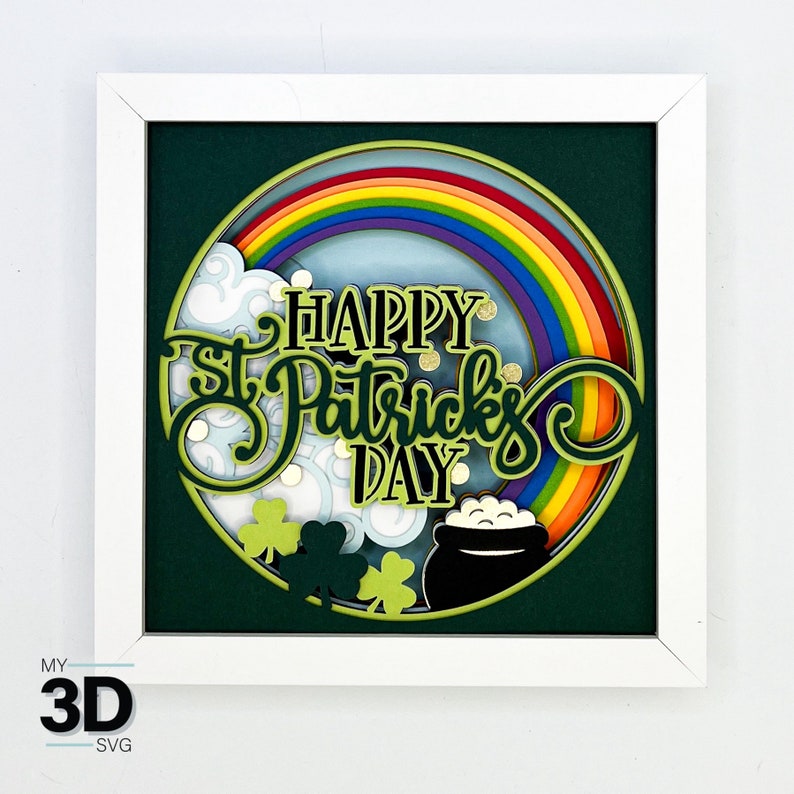 May include: A white frame with a green background and a circle in the center. The circle has a rainbow, clouds, shamrocks, and the text "Happy St. Patrick's Day".