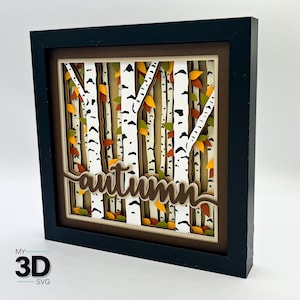 May include: A framed 3D layered art piece featuring a birch tree forest scene with the word "autumn" in a cursive font. The artwork has white birch tree trunks with black markings, and colorful fall leaves in shades of yellow, orange, and green.