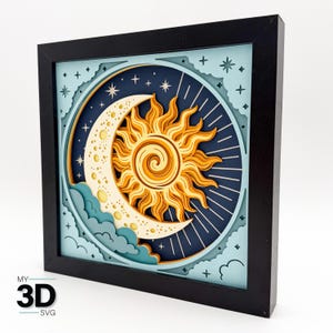 May include: A square black frame containing a multi-layered paper art piece featuring a yellow sun with swirling rays overlapping a cream-colored crescent moon with small circular cutouts, set against a dark blue sky with light blue clouds.