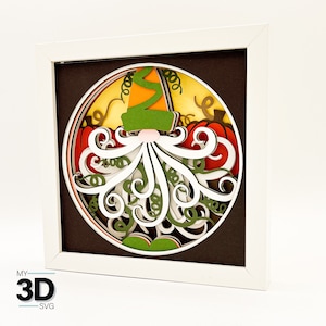 May include: A 3D paper craft of a gnome with a green hat and white beard, surrounded by pumpkins and vines. The craft is framed in a white frame.
