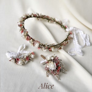 May include: A set of three dried flower arrangements, including a crown, a bracelet, and a boutonniere. The flowers are mainly white and pink, with some brown stems. The text "Alice" is written in the centre of the image.