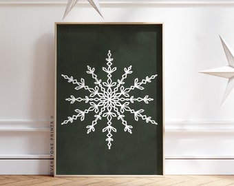 Könnte beinhalten: Ein weißes Schneeflocken-Design auf dunkelgrünem Hintergrund. Der Druck ist gerahmt und hängt an einer weißen Wand mit weißen Papiersternen, die von der Decke hängen.