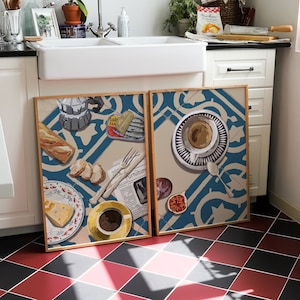 May include: Two framed illustrations of a breakfast scene with a blue and white tiled background. The left illustration features a coffee cup, bread, cheese, and a can of sardines. The right illustration features a coffee cup, a fig, and a newspaper.