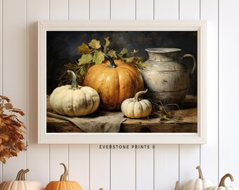 May include: A framed painting of a still life featuring three pumpkins and a vintage pitcher. The pumpkins are a mix of orange and white, and the pitcher is a light blue with a distressed finish. The painting is set against a dark blue background.