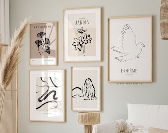 May include: Four minimalist black and white line art prints with a beige background. The prints feature a stylised flower, a bird in flight, a woman lying down, and a series of abstract lines. The prints are framed in natural wood and hung on a light green wall.