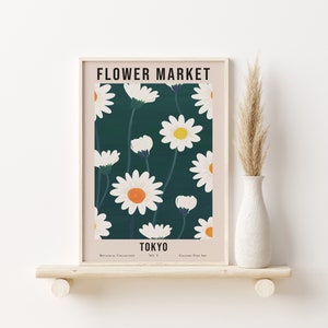 May include: A framed print with a floral design featuring white daisies with yellow centers on a dark green background. The print has the text "FLOWER MARKET TOKYO" at the top and "Botanical Collection No. V Gallery Fine Art" at the bottom.