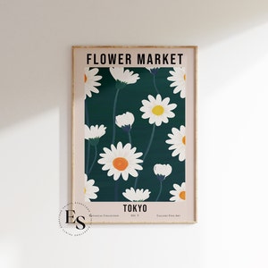 May include: A poster with a green background and white daisies with orange centers. The poster has the text "FLOWER MARKET" at the top and "TOKYO" at the bottom.