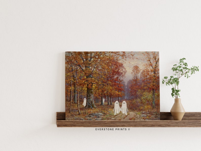 May include: A vintage painting of a forest scene with fall foliage in shades of red, orange, and yellow.  Three white ghosts are walking on a path in the woods.  The painting is framed and hanging on a wall.