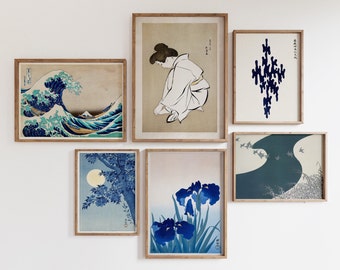 May include: A collection of framed prints featuring Japanese art. The prints depict a wave, a woman in traditional clothing, a floral design, and a pattern of abstract shapes. All prints have a white background and blue accents.