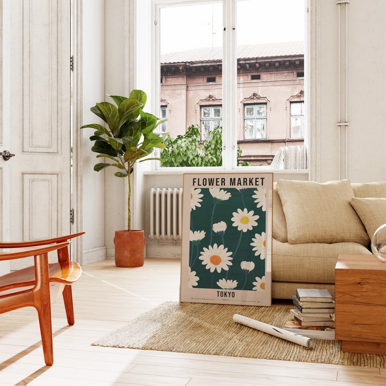 May include: A poster with a floral design featuring white daisies on a dark green background. The poster is framed in a light wood frame and has the text "FLOWER MARKET TOKYO" at the bottom.