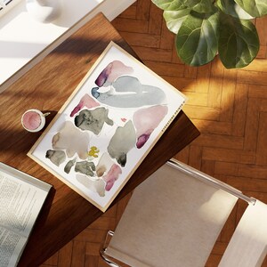 May include: A framed abstract watercolour painting with a variety of shapes and colours, including pink, purple, grey, and brown. The painting is titled "EVERYSOME PRINTS".