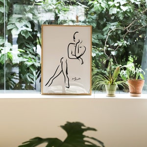 Pu&ograve; includere: Un disegno a linea nera e bianca incorniciato di una silhouette femminile. Il disegno &egrave; su sfondo bianco e la cornice &egrave; dorata. Il testo "female silhouette" &egrave; scritto in nero nella parte inferiore del disegno.
