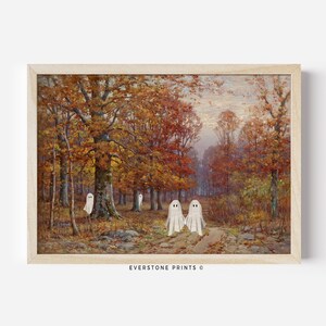 May include: A vintage painting of a forest path in autumn with four white ghosts walking along the path. The trees are a mix of orange, yellow, and red. The sky is a light blue with some clouds. The painting is framed in a light wood frame. EVERSTONE PRINTS &copy;